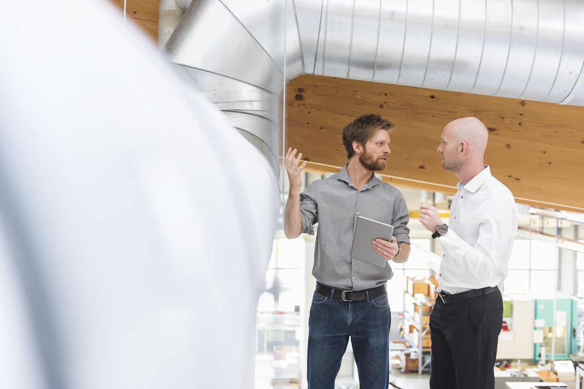 Two businessmen talking with tablet
