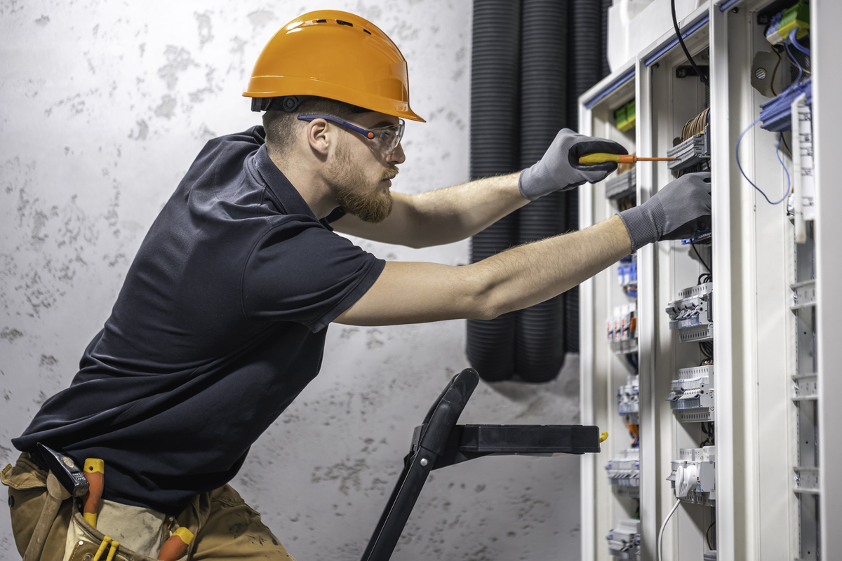 electrical tech working on circuit breaker box