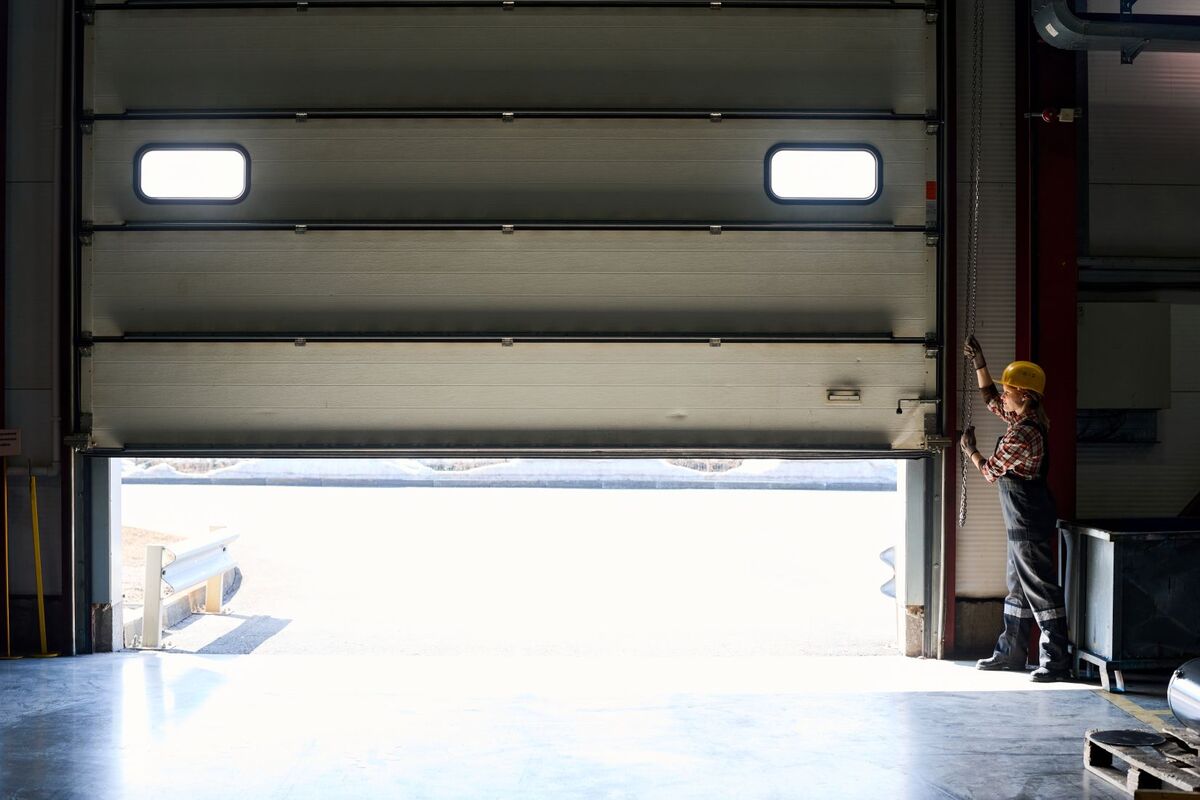 factory overhead door opened by female worker